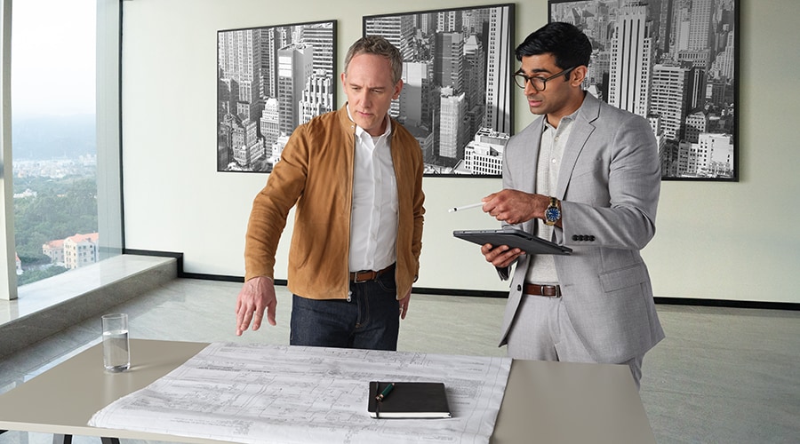 Two men discussing plans in an office building.