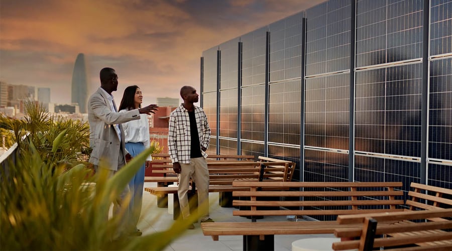 A group of people looking at a roof top solar array.