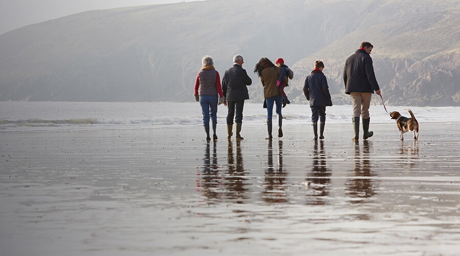 Group of people walking along the beach in the winter.