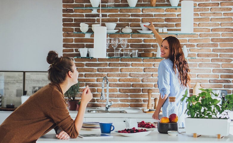 Caucasian women talking in modern kitchen.