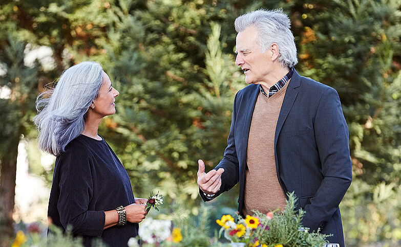 Senior couple talking at a dinner party.