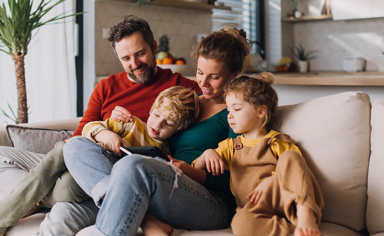 Family with young children reading a picture book together