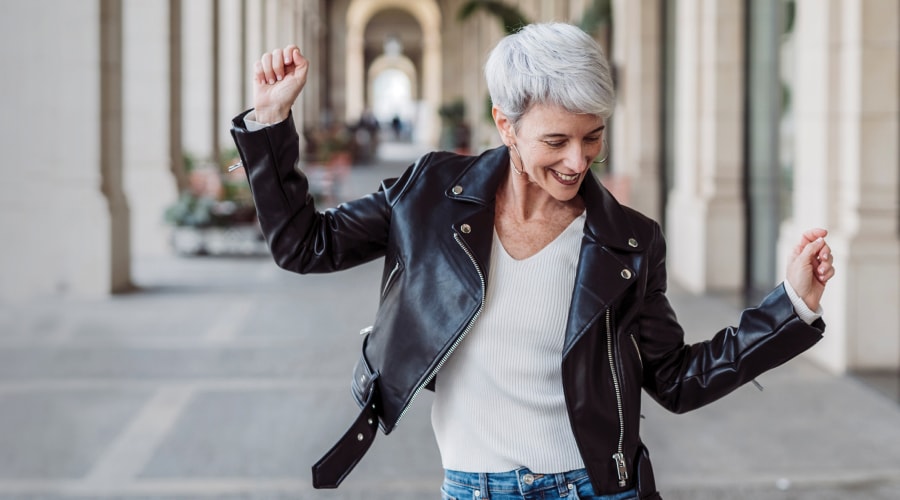 Woman with grey hair and leather jacket dancing