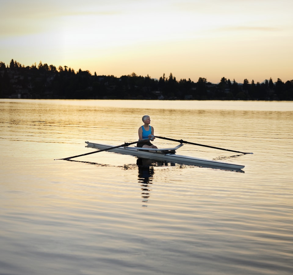 Woman in a kayak in the middle of a lake.