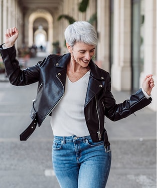 Woman with grey hair and leather jacket dancing