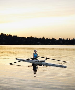 Older woman in a kayak in the middle of a lake