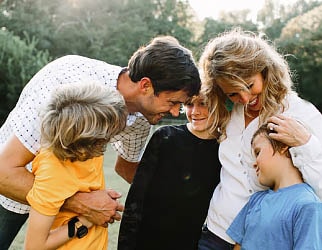 Mom, Dad, and three young kids sharing a hug