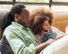 A father reading to young daughter