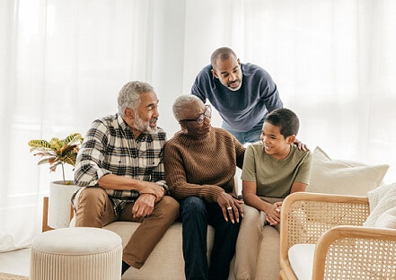 Grandparents with their son and grandson in their living room.