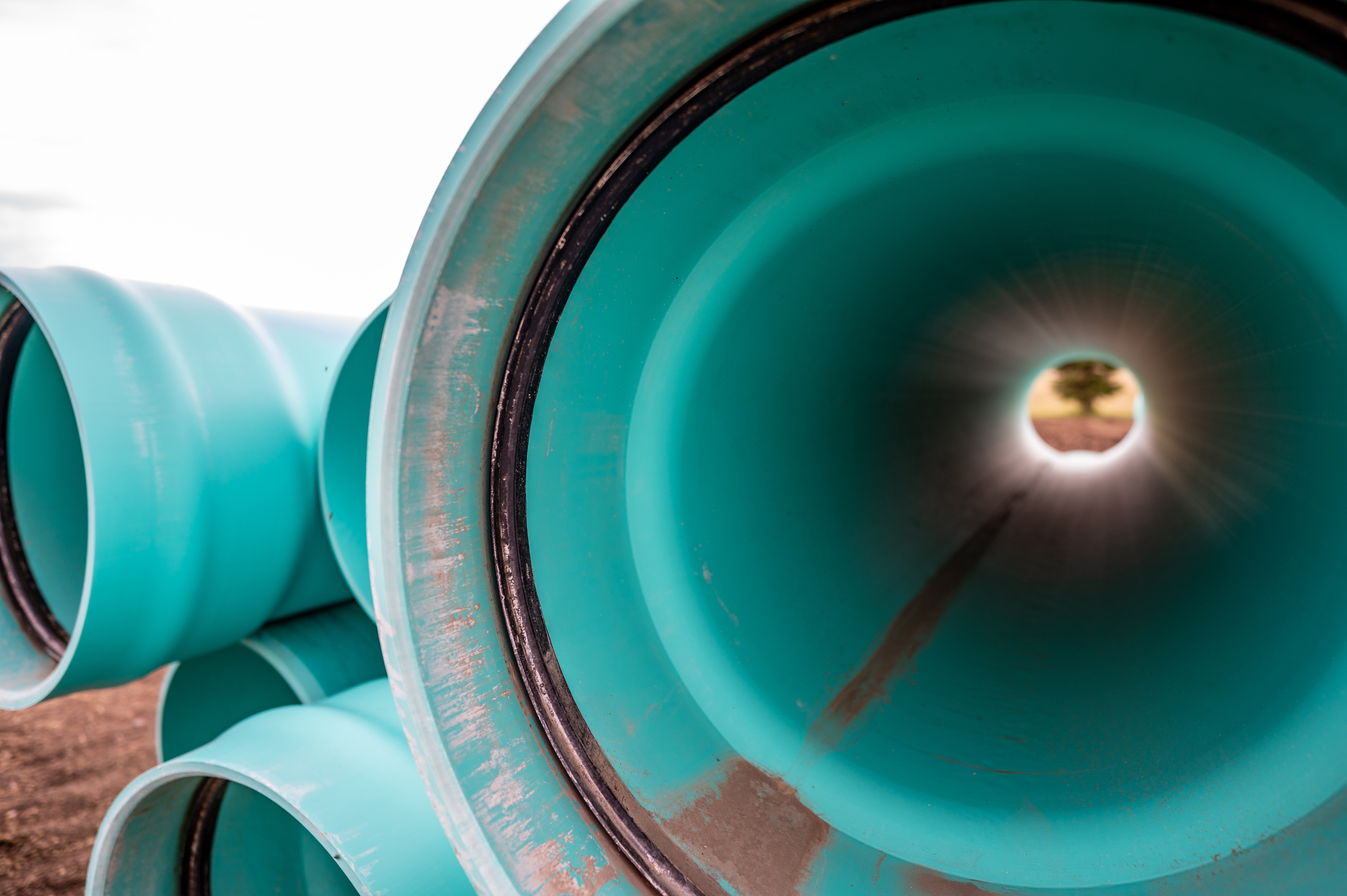 View to bright field through teal pipe 