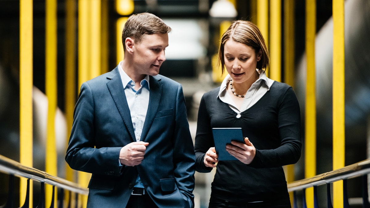 Lady and gentleman discussing business matter in professional clothes with a black                 and yellow background               