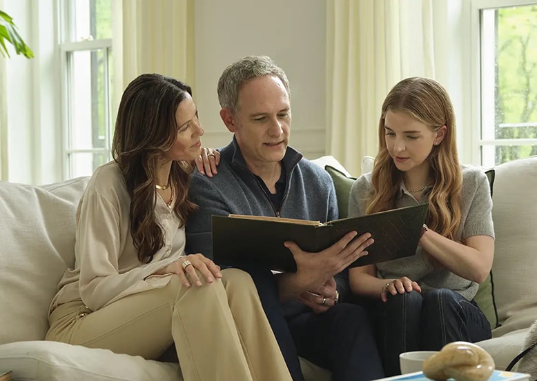 A couple with there daughter sitting and reading together